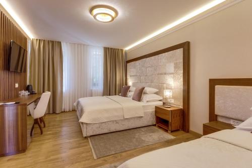 普利特维采湖格兰德湖酒店的酒店客房配有两张床和一张书桌