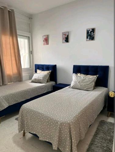 艾尔亚奈Residence Mariem的一间卧室设有两张床和窗户。