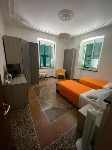 热那亚ALBERGO LOCANDA DIANA的一间卧室配有橙色的床和电视
