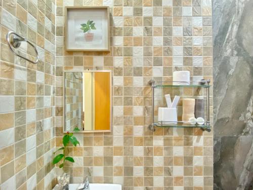 长滩岛Everrich Boutique Resort Boracay的瓷砖浴室设有镜子和水槽