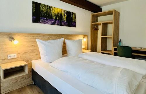 勒芬根Landhotel Tanneneck - ideal für Gruppen, Familien und Hunde的卧室配有白色的床和书桌
