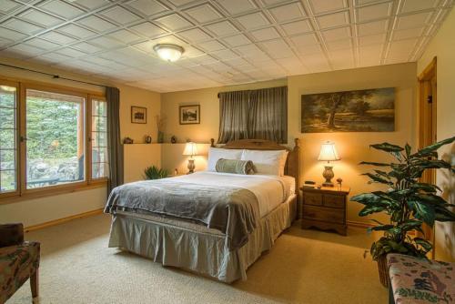 因弗米尔Pine Ridge, Log Home with Lake View and Backyard的一间卧室,里面装有床和植物