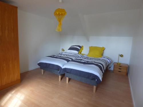 Bégardgite de kerveg的一间卧室配有蓝色和黄色枕头的床