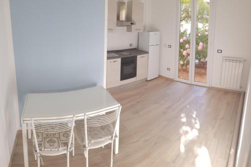 菲纳莱利古雷Borgo and Bike的一间厨房,里面配有白色的桌子和椅子