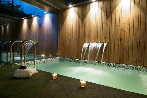 Bonansa博南萨特拉酒店的浴室设有喷泉和蜡烛的游泳池