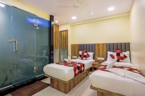 孟买Hotel BKC Corporate Inn的一间卧室设有两张床和淋浴。