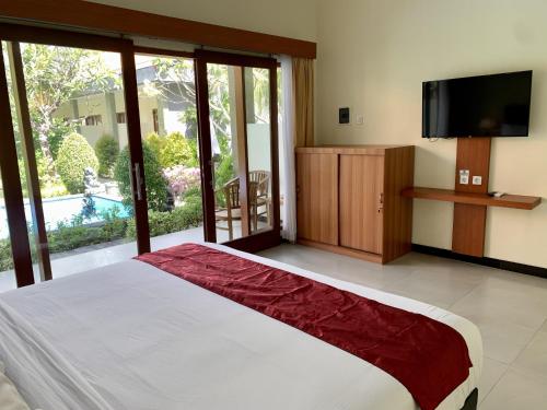努沙杜瓦Davit Guesthouse Nusa Dua的一间卧室设有一张大床和一台平面电视。