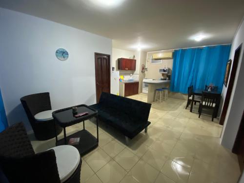 曼塔Playa Suites, cerca del Malecon的客厅配有黑色沙发和桌子