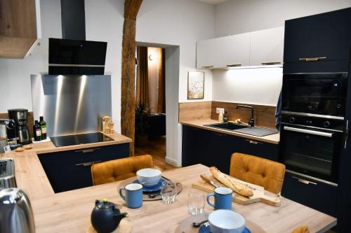 鲁昂L'escale du Gros Horloge的带木桌和椅子的厨房以及带水槽的厨房。