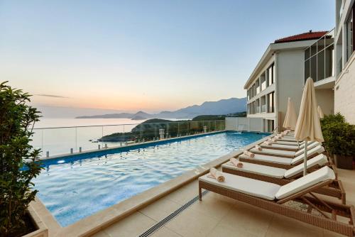 斯韦蒂·斯特凡ĀNANTI Resort, Residences & Beach Club - The Leading Hotels of the World的一座带躺椅的游泳池位于大楼旁