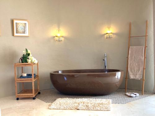 罗萨斯Casa de l’Albada的浴室里设有大型棕色浴缸,配有两盏灯