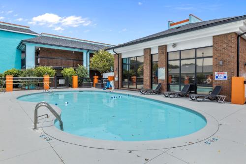 莫尔黑德城Garnet Inn & Suites, Morehead City near Atlantic Beach的大楼前的大型游泳池