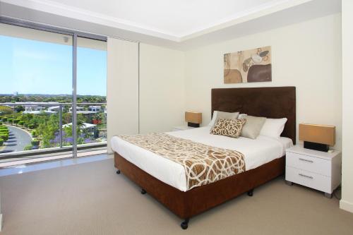 黄金海岸特色海滨公寓酒店的一间卧室设有一张床和一个大窗户