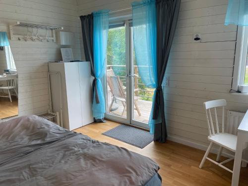 MyggenäsStuga的一间卧室设有一张床和一个滑动玻璃门