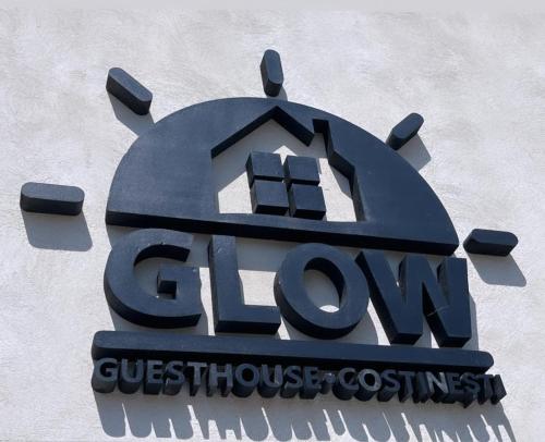 科斯蒂内什蒂Glow GuestHouse Costinesti的建筑物一侧的标志