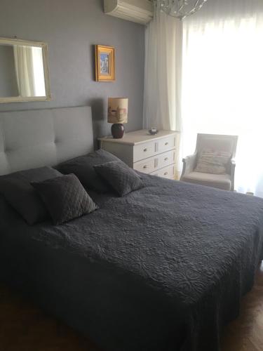 戛纳Lou Suquetan的卧室配有床、椅子和窗户。