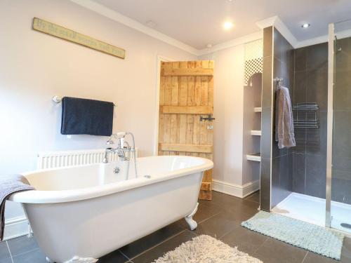 德比Cute Remarkable quirky 2 Bed House in Derby的带淋浴的浴室配有白色浴缸。