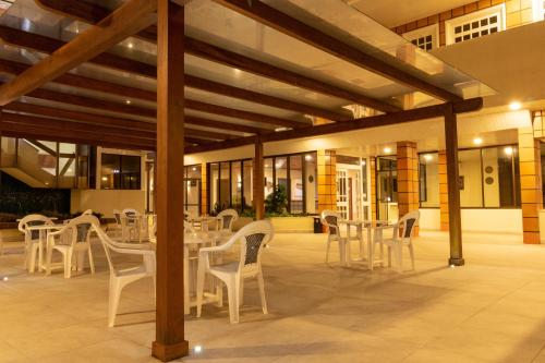 弗洛里亚诺波利斯Ilhasul Hotel Residencia的大楼内带白色桌椅的庭院
