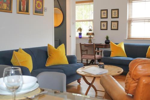 巴斯Sydney Wharf House的客厅配有蓝色沙发和黄色枕头。