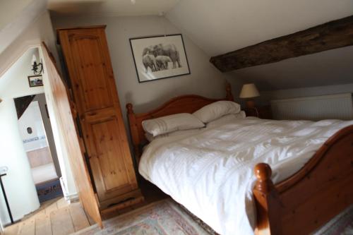 RaglanMedieval Cottage in rural Monmouthshire.的一间卧室配有一张木架大床