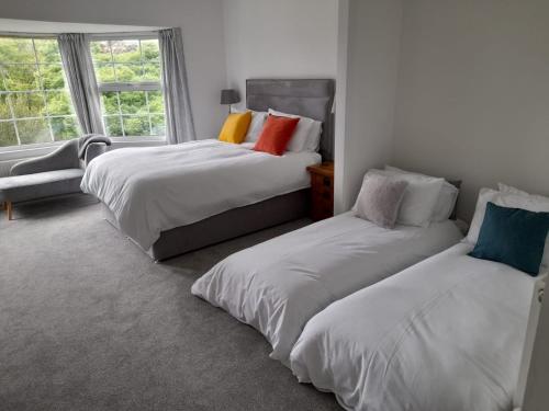 赫尔斯顿Bosloe的一间卧室设有两张床和窗户。
