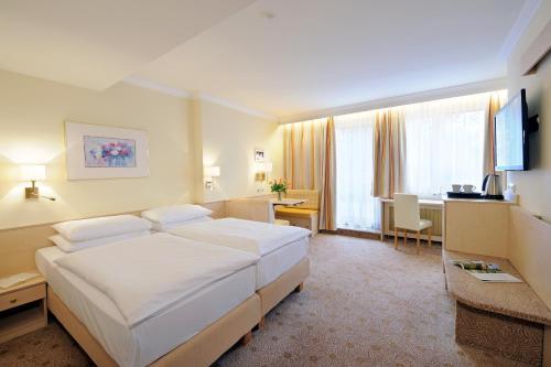 萨尔茨堡舍雷尔酒店的酒店客房设有一张大床和一张书桌。