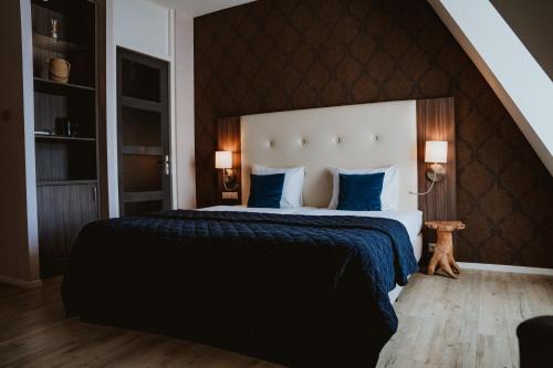 迪尔斯泰德附近韦克Hotel Brasserie Florian的一间卧室配有一张带蓝色枕头的大床