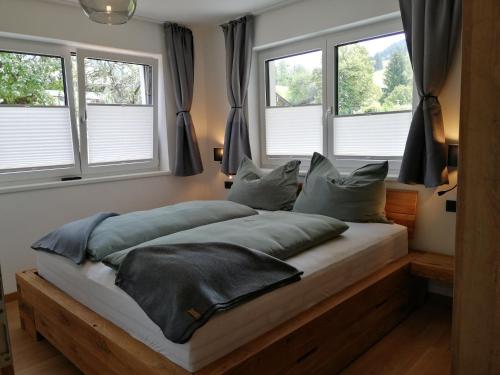 玛丽亚阿尔姆Das Prinzenberg Appartement的卧室内的一张床位,设有三扇窗户