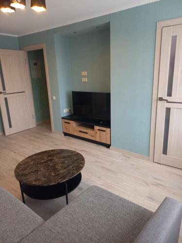 陶格夫匹尔斯Kandavas Street City Center Apartment的客厅配有桌子和平面电视。