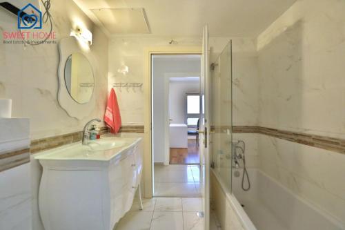 内坦亚Sea view family relax apartment的带浴缸、水槽和淋浴的浴室