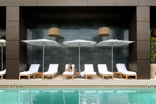 奥兰多ette luxury hotel & spa的坐在游泳池旁椅子上的女人