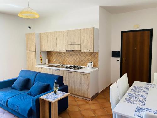 斯卡莱阿Marina Apartament的一间带蓝色沙发的客厅和一间厨房