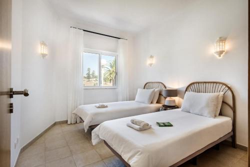 卡武埃鲁Modern and Spacious Two Bedroom Apartment的配有2张床的白色墙壁和窗户。