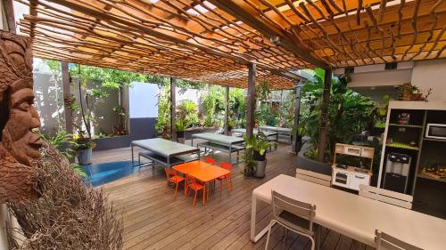 努美阿Gondwana City Art的木制甲板上配有桌椅的庭院