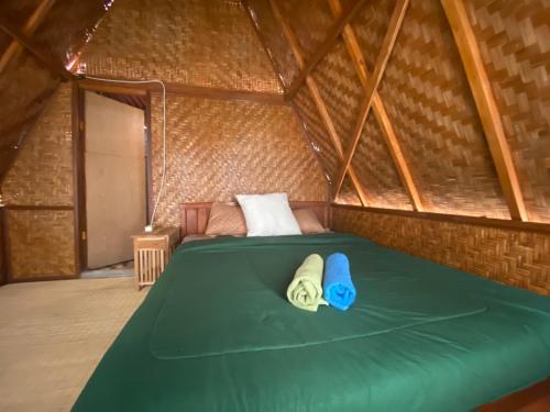 金塔马尼D' Tepi Danau Glamping的蒙古包内带绿床的房间