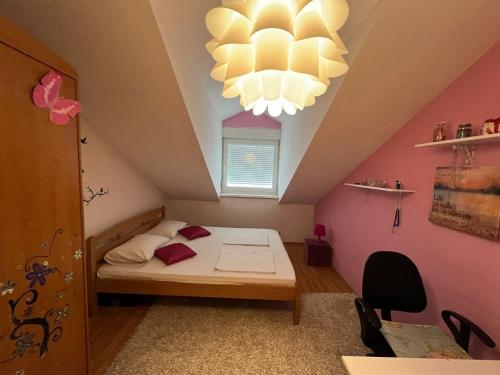 萨拉热窝Holiday Home Hodo的小房间设有一张床和一个吊灯