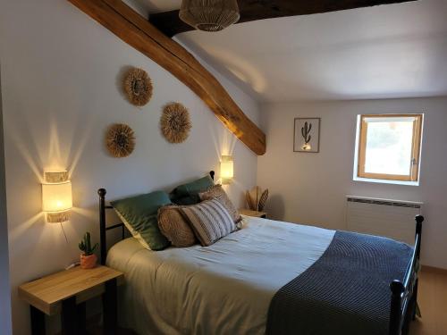 BouligneuxLe cœur des Dombes的卧室配有带枕头的床铺和窗户。