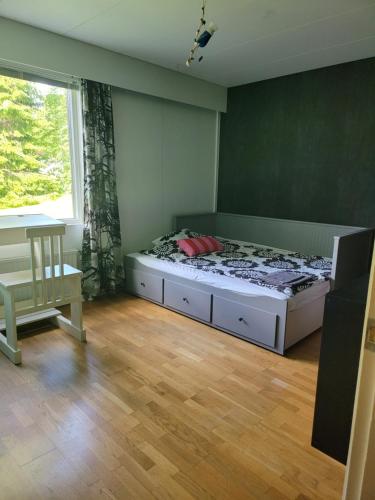 耶姆赛Niittyvilla Apartments的一间卧室配有一张床、一张桌子和一个窗户。