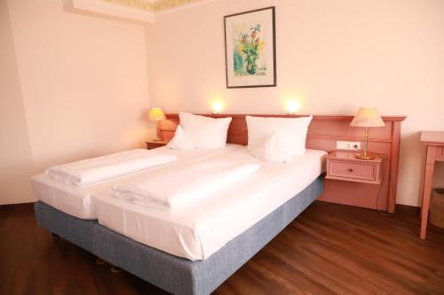 贡岑豪森阿尔特米尔塔尔公园酒店的一间卧室配有一张带白色床单的大床
