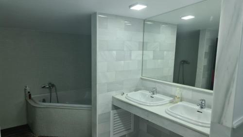 莫哈卡尔TRIPLEX DE LUJO EN MOJACAR的浴室设有2个水槽、浴缸和镜子