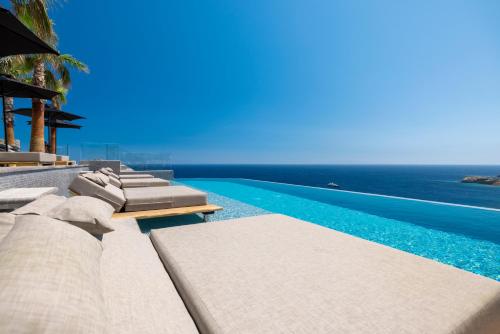 天堂海滩Tropicana Hotel , Suites & Villas Mykonos的一个带躺椅的游泳池和海洋