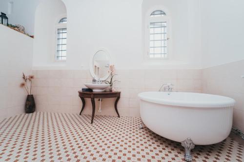 MoosteMooste Viinavabriku Hotell & Restoran的浴室配有白色浴缸和镜子
