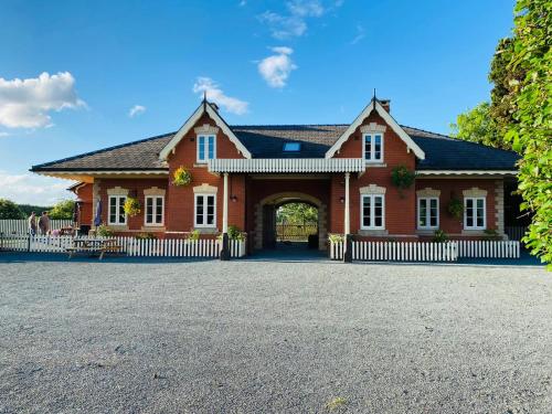 赫里福德The Booking Office, Stoke Edith Station的一座带拱门的大型红砖房子