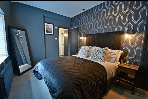 克利夫罗Boutique cottage set in historic town of Clitheroe的一间卧室配有一张带蓝色墙壁的大床