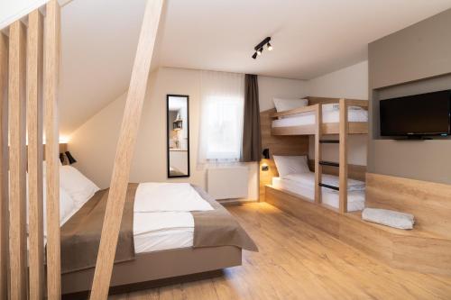 RadomljePenzion Repanšek的一间卧室配有两张双层床和一台平面电视