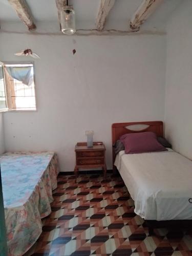 MaldáCa l'Anna i l'Antonino的一间带两张床的卧室,铺有瓷砖地板。