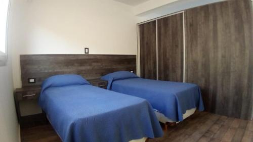 圣胡安Abril Dptos Temporarios的医院房间两张床铺,配有蓝色床单