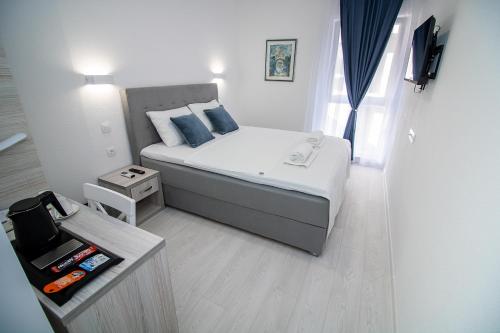 莫斯塔尔Villa Sonata的小卧室配有带蓝色枕头的床