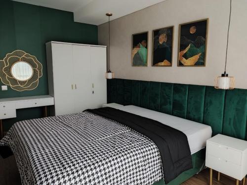 SeturanApartemen Strategis Yogyakarta的一间卧室设有一张带绿色墙壁的床