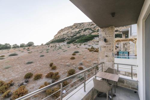 马塔拉Luxury Villas Ammos in Style的一个带桌椅和山丘的阳台